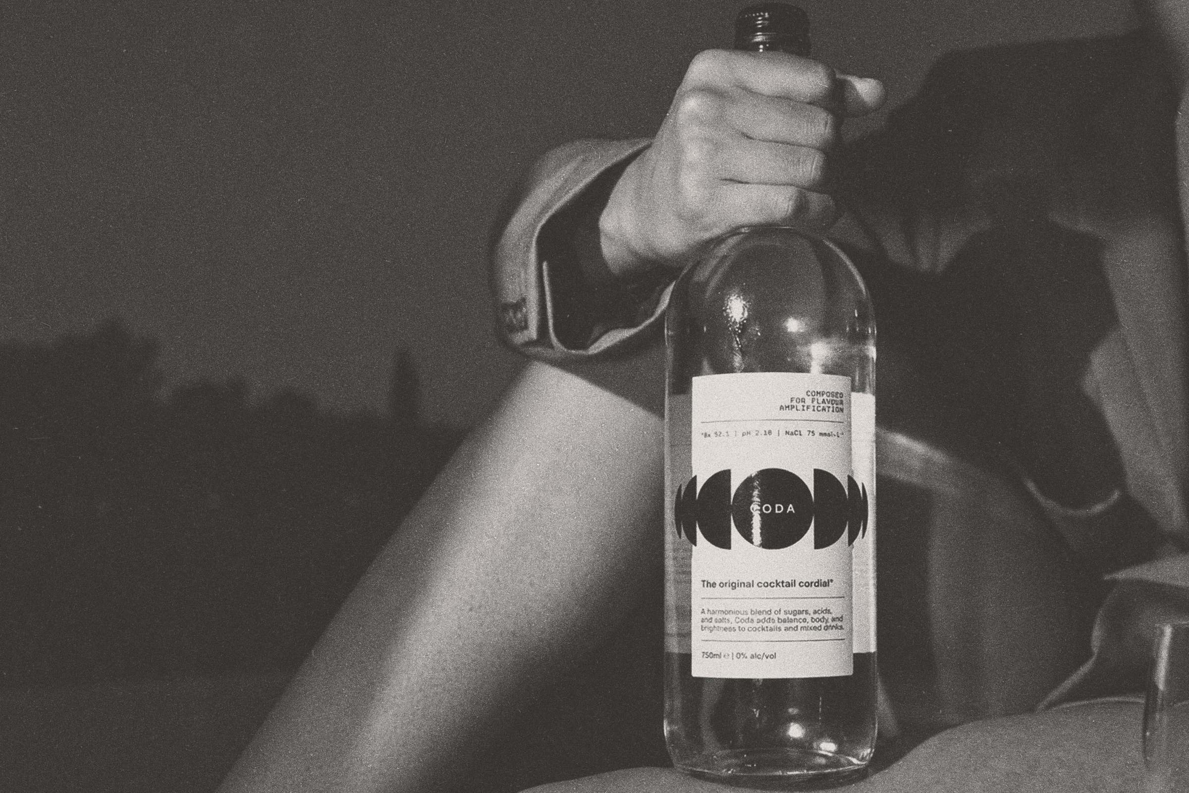 Poolside at dusk, the bottle in hand